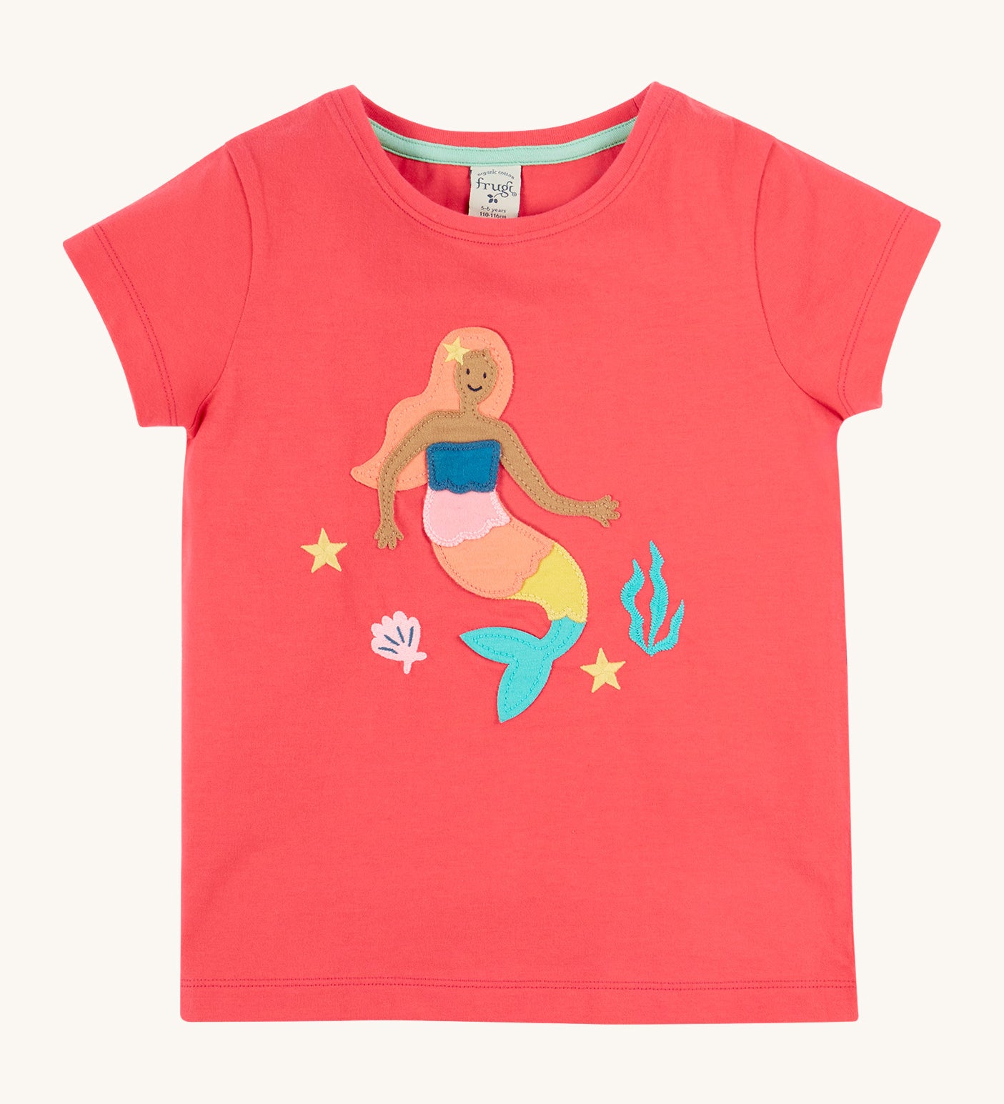 Frugi Tamara t-shirt. A GOTS organic cotton light pink short sleeve top with a mermaid, shell, coral and stars appliqué on the front. Features a light turquoise trim on the inside of the neck
