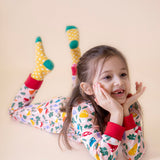 A child lying down and wearing the Frugi Zelah fun guys all in one zip suit available at Babipur. A GOTS organic cotton all in one suit light pink with a playful woodland inspired prints and red cuffs.