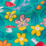 A close up of the Frugi kids kyla outfit in tulip/wild woods showing the woodland theme print detail on the turquoise bottoms 