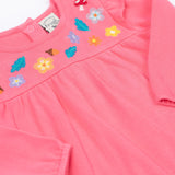 A close up of the Frugi kids kyla outfit in tulip/wild woods showing the long sleeves pink top with frilled shoulders. Features woodland themed embroidery. 