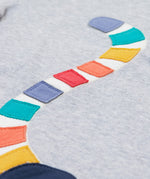 A close up of the Frugi kids grey marl lemur character t- shirt. showing the multicoloured tail of the lemur appliqué on grey marl organic cotton fabric