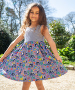 A child wearing the Frugi Summer Holiday Dress with a Lemur Laughs print design