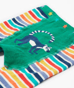 A close up of the Frugi baby lemur knitted leggings showing a navy lemur on a green panel on the front of the leggings on organic soft cotton fabric