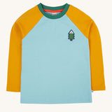 The front of the Frugi Children's Leo raglan long sleeved top. The body of the top is light blue with yellow gold coloured sleeves and a contrasting dark green neck collar. The front has a small fir tree on the chest.