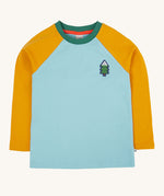 The front of the Frugi Children's Leo raglan long sleeved top. The body of the top is light blue with yellow gold coloured sleeves and a contrasting dark green neck collar. The front has a small fir tree on the chest.