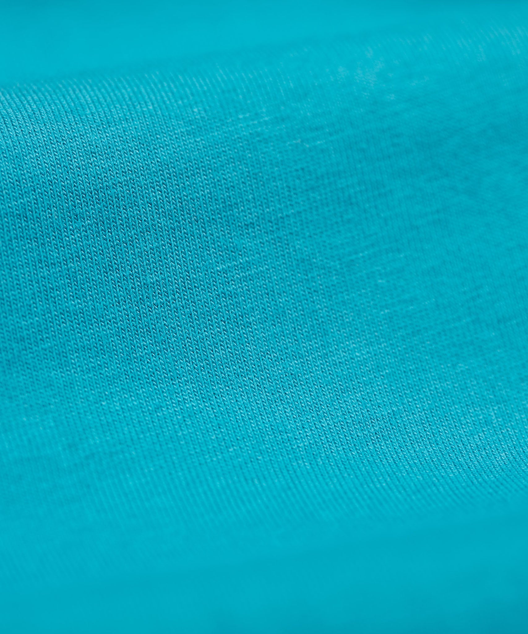 A close up of the Frugi kids libby leggings in boat blue showing the knit detail on bright blue organic cotton fabric.