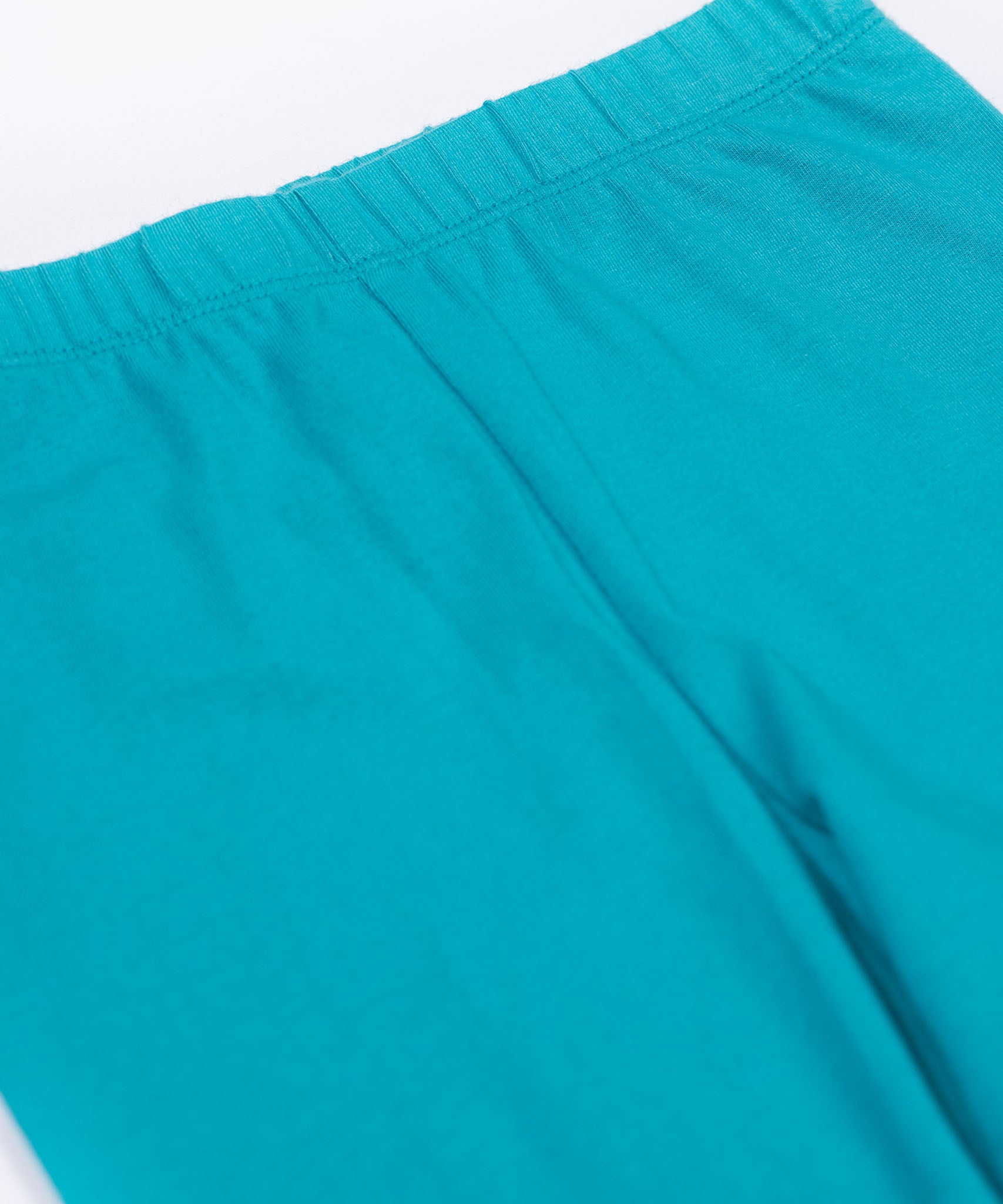 A close up of the Frugi kids libby leggings in boat blue showing the elasticated waist band detail on bright blue organic cotton fabric.