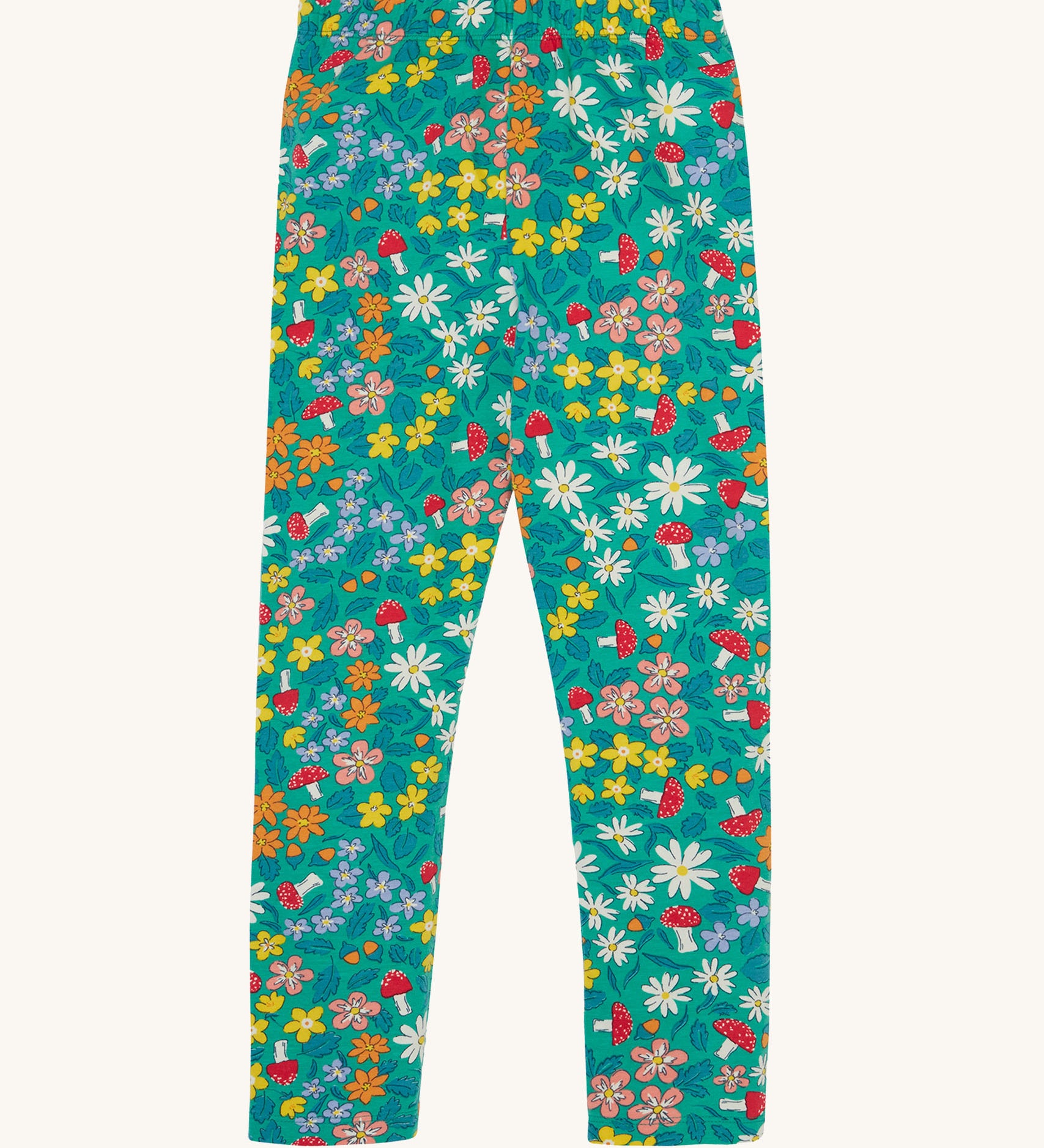 Frugi Libby leggings with a wild woods, botanical design on a green background. 
