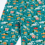 Close up of the front of the Frugi organic cotton libby leggings with a winter drives print showing the elasticated waist. Teal background with all over print featuring reindeer, houses, trees and vehicles.
