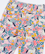 Close up of the Frugi organic cotton libby leggings with a floral flight print showing the elasticated waist. Pink background with all over print featuring flowers, foliage and Pegasus.