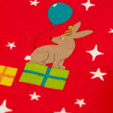 Close up of the rabbit on the Frugi organic cotton libby leggings with a perfect paw-ty party print. Red background with all over print featuring pets with party hats surrounded by gifts and baloons.