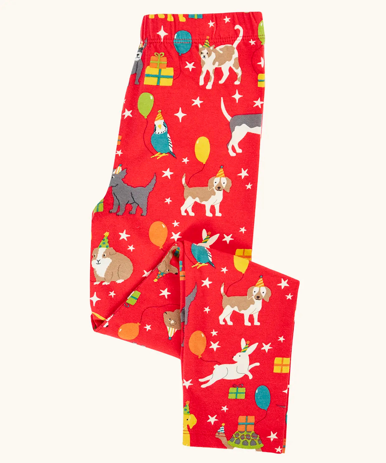 Frugi organic cotton libby leggings with a perfect paw-ty party print shown folded. Red background with all over print featuring pets with party hats surrounded by gifts and baloons.