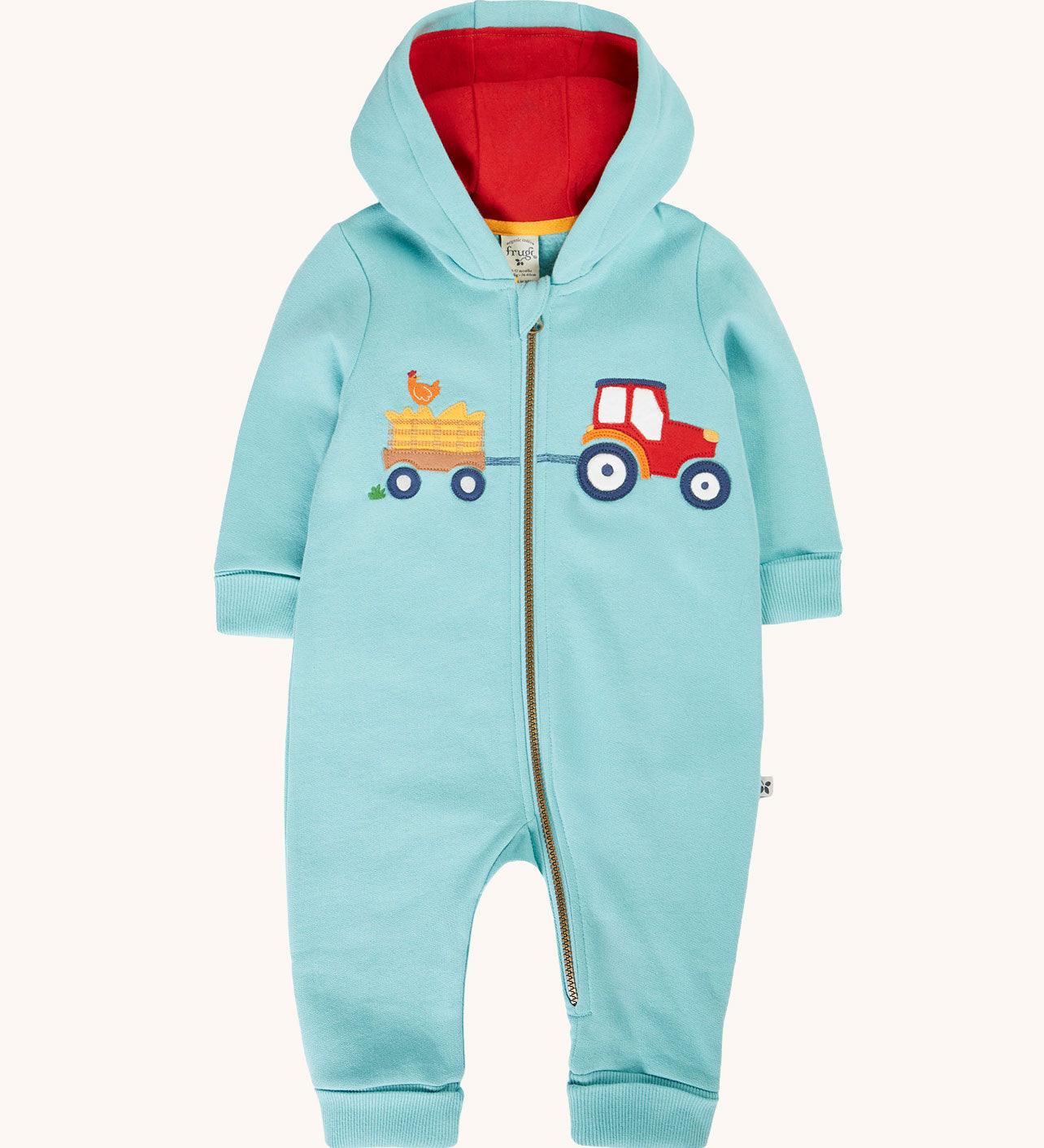 Frugi soft green all in one organic cotton zip suit with tractor and trailer applique on the front and red lining inside. The front zip extends from the neck down to the ankle.