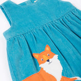 A close up of the Frugi Lily blue organic cotton cord children's dress showing the fox applique in the corner.