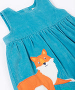A close up of the Frugi Lily blue organic cotton cord children's dress showing the fox applique in the corner.