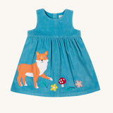 The Frugi Lily blue organic cotton cord children's dress with fox, mushroom and flowers appliques on the front.