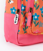 A close up of the bottom of the Frugi little adventures fun flowers backpack showing the zip detail and pink trim. 