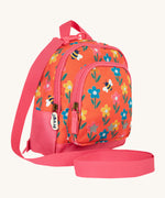 Side view of the Frugi little adventures fun flowers backpack showing the zip detail and handy pink rein that's clipped to the top of the bag.