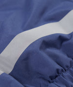 A close up of the reflective strap on the Frugi little kids navy waterproof dungarees.