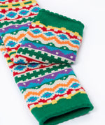 A close up of the green cuff details on the Frugi organic cotton little knitted leggings with a bear fair isle design. 
