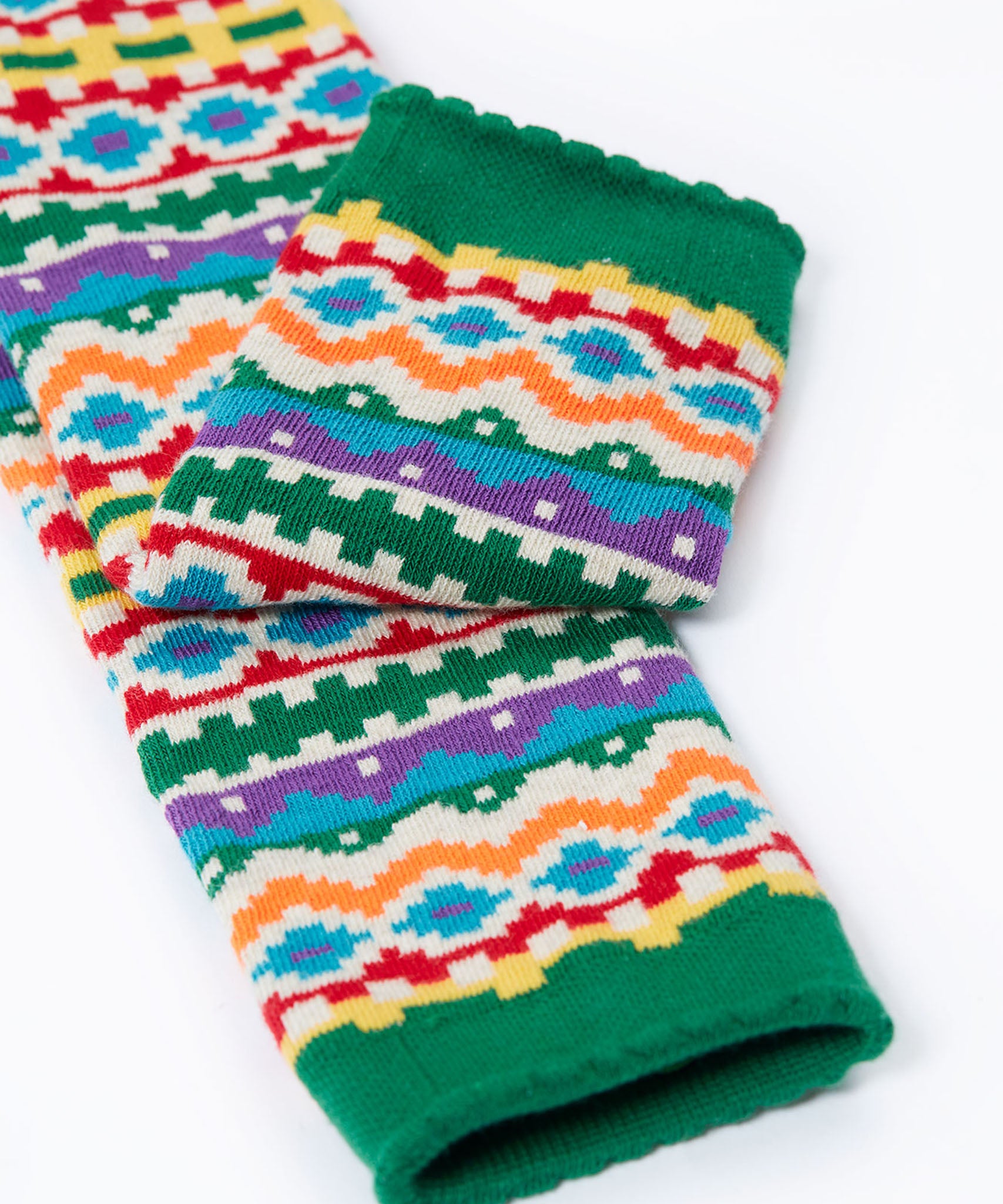 A close up of the green cuff details on the Frugi organic cotton little knitted leggings with a bear fair isle design. 