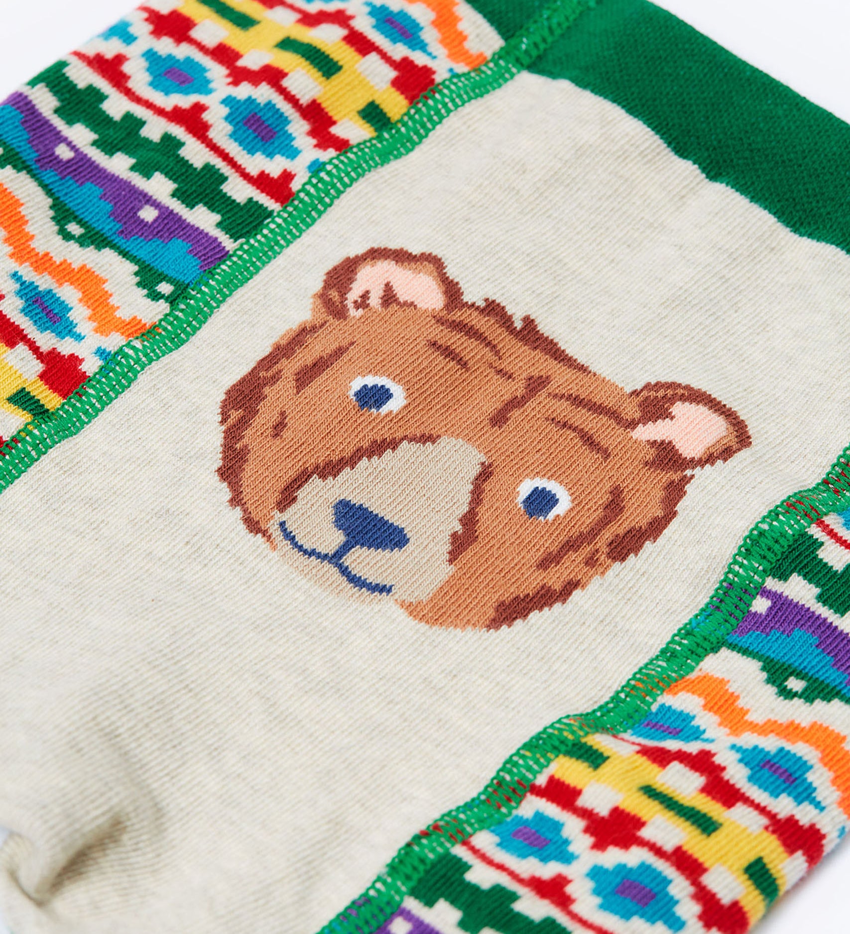 A close up of the brown bear on the bottom of the Frugi organic cotton little knitted fair isle leggings.