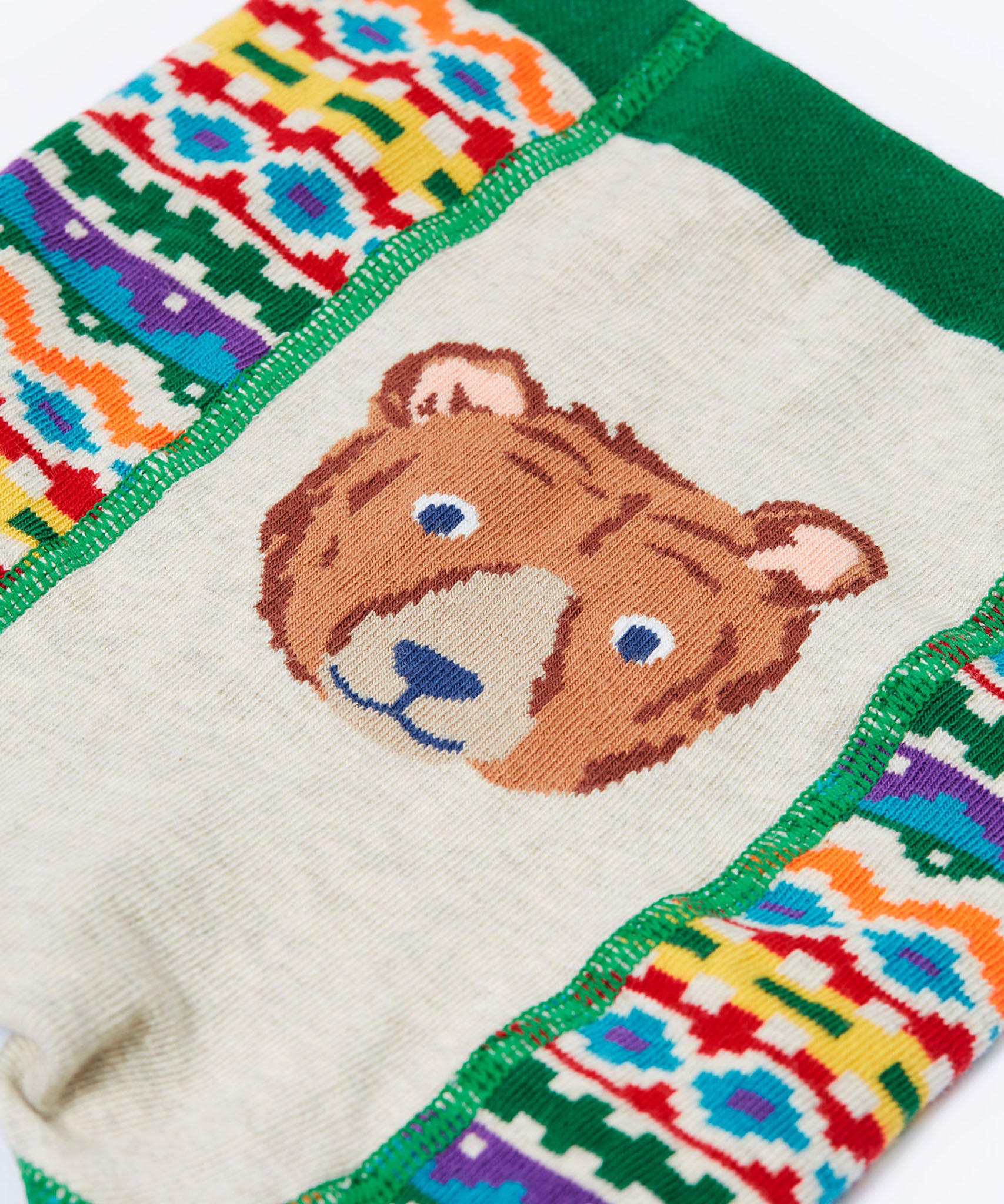 A close up of the brown bear on the bottom of the Frugi organic cotton little knitted fair isle leggings.