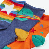 Close up of the Frugi little roly bamboo socks in a 3 pack with spac edesign. Rainbow stripe with white star pair, navy with planet pair and an orange with rainbow stars pair.