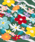 A super close up view of the Frugi Louise embroidered heart holly green breton stripe long sleeved top.  