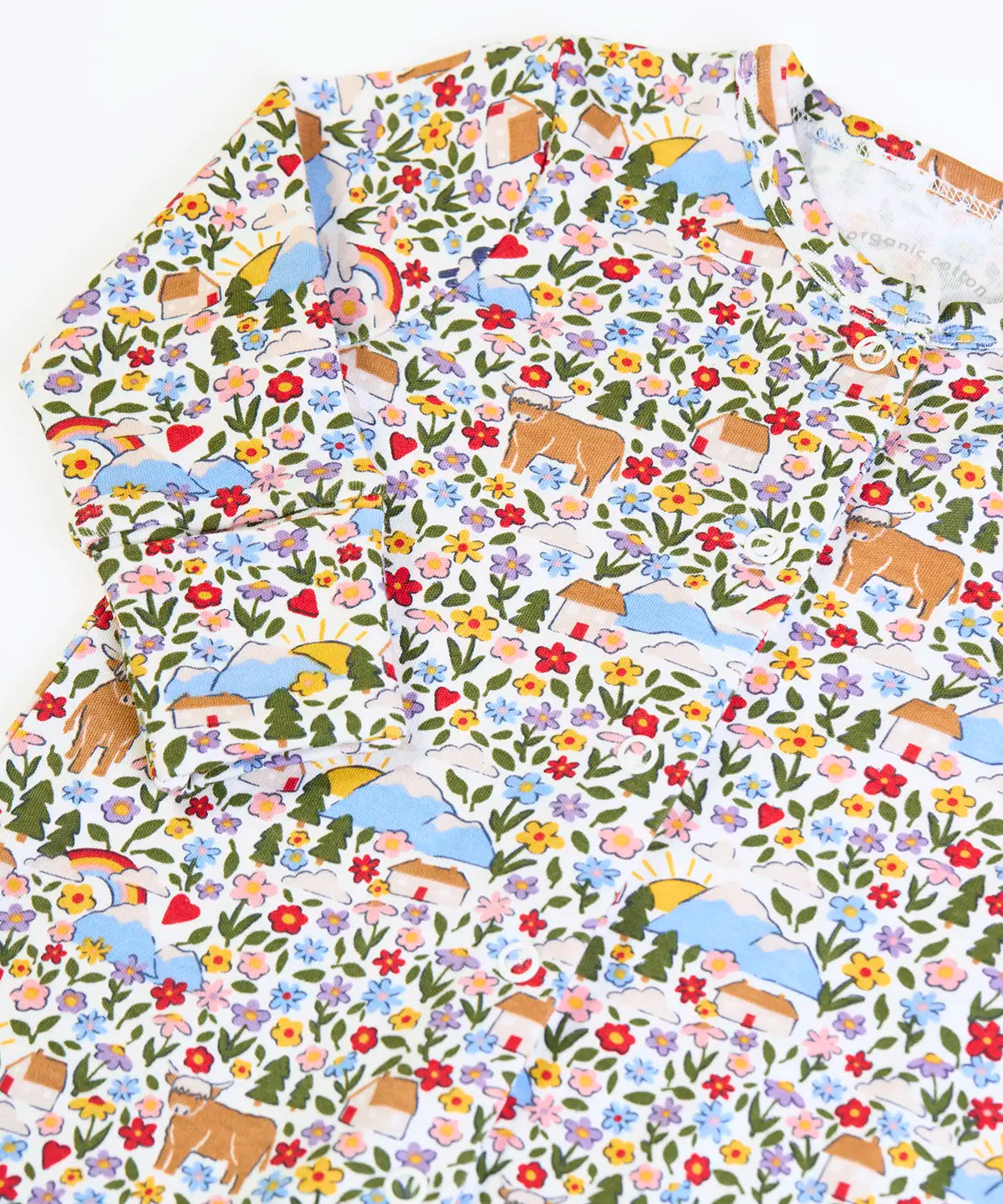 Close up of the print on the Frugi lovely babygrow with an all over highland fields print. 