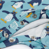 A close up of the popper closure on the Frugi Lovely babygrow in a blue penguin waddle design.