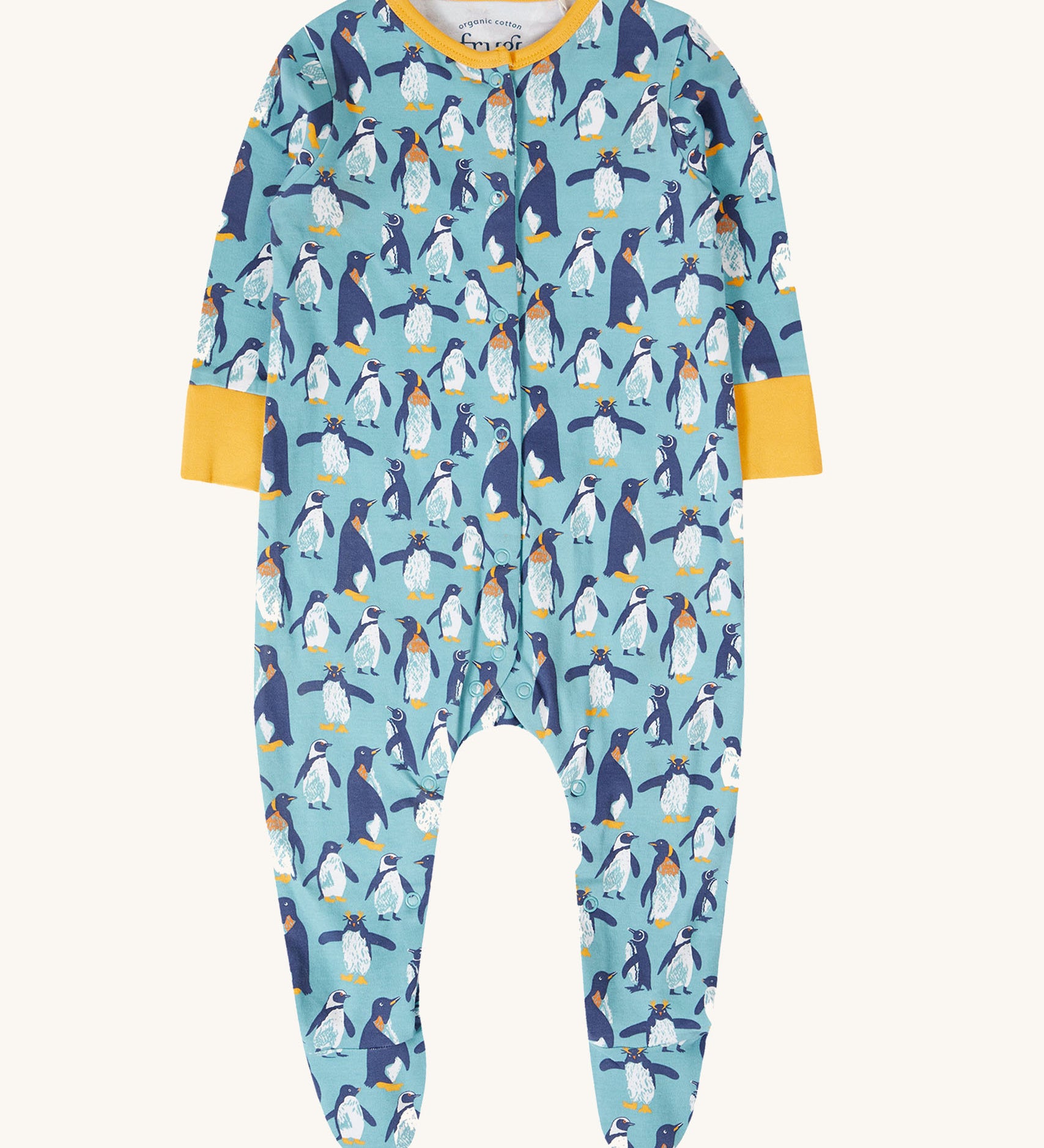 The Frugi Lovely babygrow in a blue penguin waddle design. A hand illustrated style, all over penguin print on a blue background with yellow gold coloured fold-able cuffs on the arms and yellow gold coloured binding on the neck. 