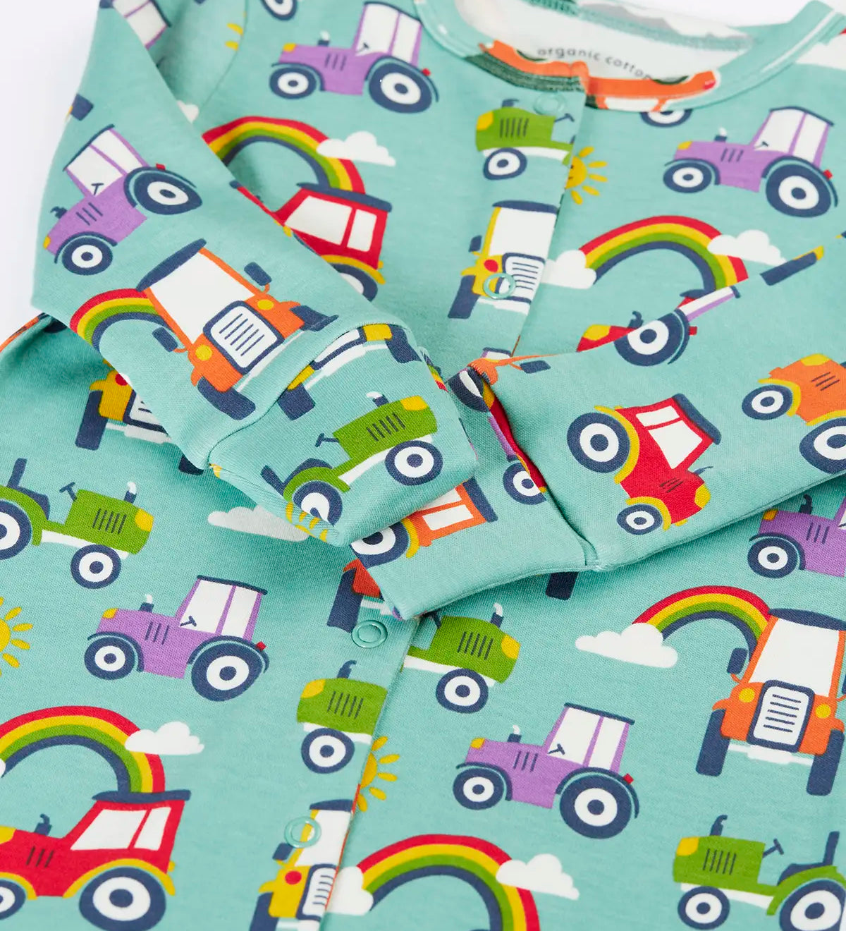 Close up of the fold over mitts on the Frugi organic cotton lovely babygrow sleepsuit with an all over terrific tractors print on a blue background. 