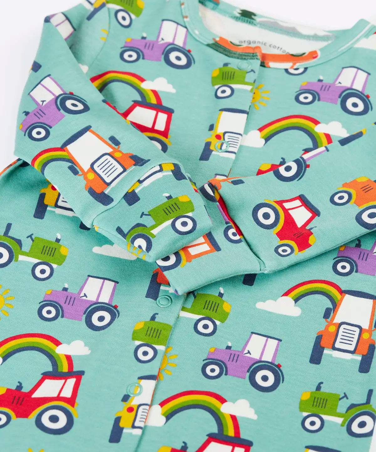 Close up of the fold over mitts on the Frugi organic cotton lovely babygrow sleepsuit with an all over terrific tractors print on a blue background. 