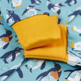 A close of the yellow gold coloured fold-able cuffs on the Frugi Lovely babygrow in a blue penguin waddle design.