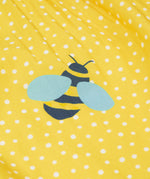 Close up of the Frugi kids lowen flower dress - Showing a yellow bee print on yellow with white spots organic cotton fabric