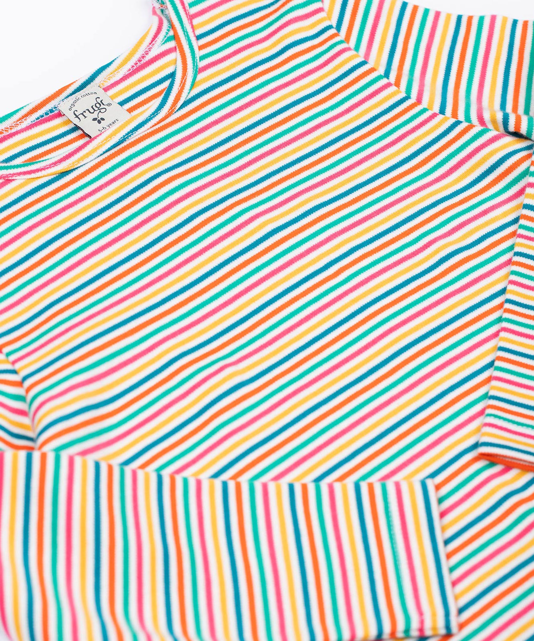 A close up of the Frugi Lucia Multi Stripe Long Sleeved Organic Cotton Top with the sleeves folded in. A multi-coloured, white, blue, yellow, pink and green thin striped design made with organic cotton.