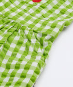 Close up of the Frugi kids macaw ginham, veg culotte dungarees. Sowing the side pocket detail on green and white gingham organic cotton fabric