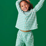 Child wearing the Frugi magic nights organic cotton hayley traditional pyjamas. Light green and white check style with hearts and stars. Pink frill around the collar and across the chest.