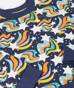 A close up of the print on the Frugi child's Organic Cotton Mawnan Jumper with a Magic Skies print. A navy background with white stars and rainbow swirls all over. This jumper is a part of a wide range of organic cotton clothing for children available here at Babipur. 