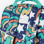 A close up of the back of the Frugi magic stars explorer backpack showing the name tag detail on the top of the bag in between the shoulder straps.