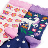 Close up of the Frugi magical organic cotton frill socks 2 pack. One navy pair with flowers and a pegasus and a purple frill. One white pair with flowers and butterflies with pink frill.