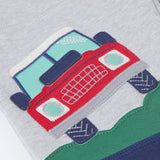 A close up of the red truck applique on the Frugi Malpas Placement Grey Joggers with Trucks.