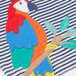 A close up of the Frugi Marco Outfit's t-shirt, in Navy Blue Stripe with an embroidered Parrot.