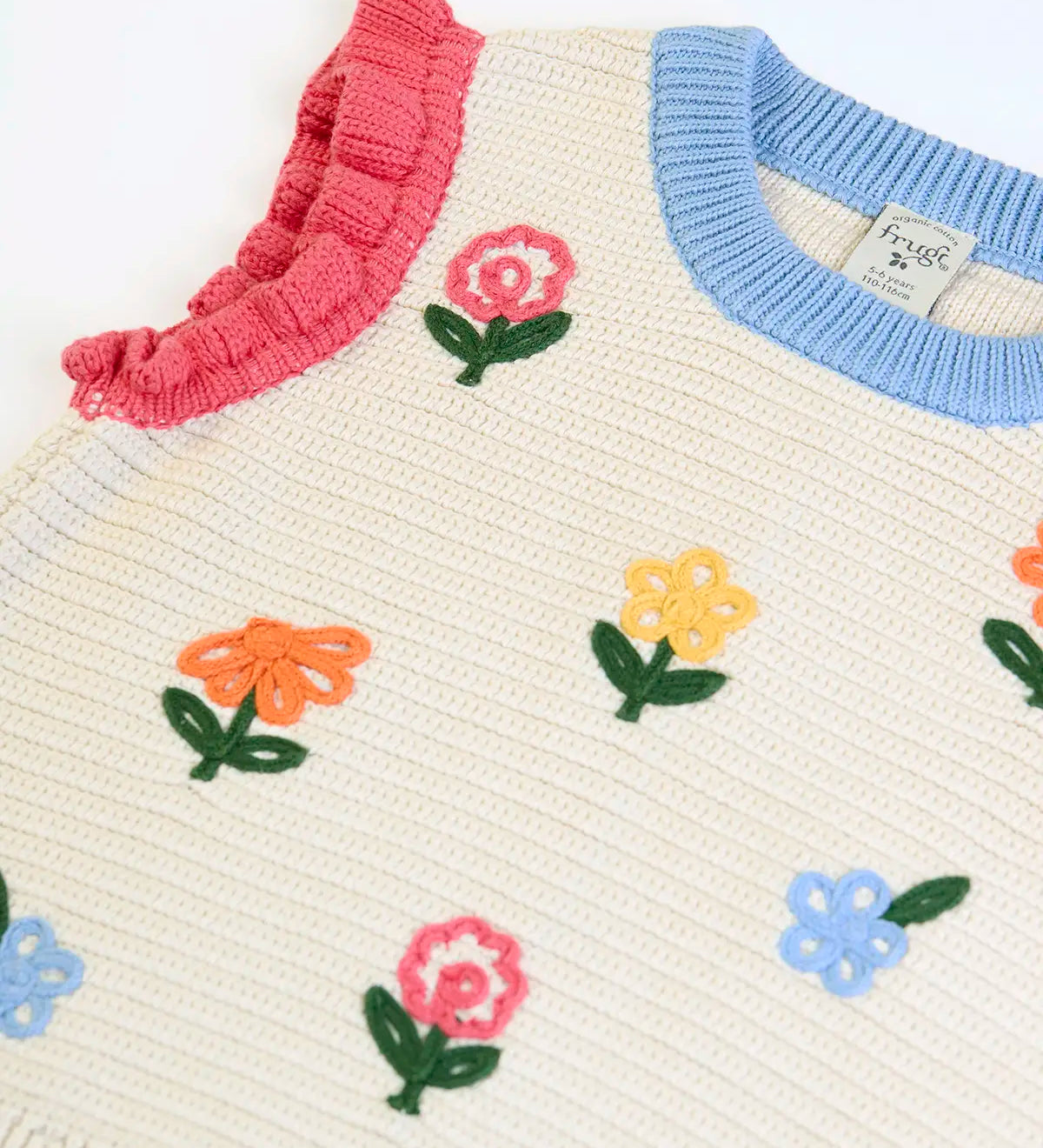 Frugi GOTS 100% organic cotton natural knitted tank top in cream showing a baby blue neck line, pink shoulder cuffs and flower embroideries