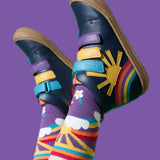 A child wearing the Frugi meadow high top children's shoes with matching purple coloured rainbow, sun flower design Frugi socks. 