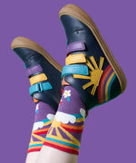A child wearing the Frugi meadow high top children's shoes with matching purple coloured rainbow, sun flower design Frugi socks. 