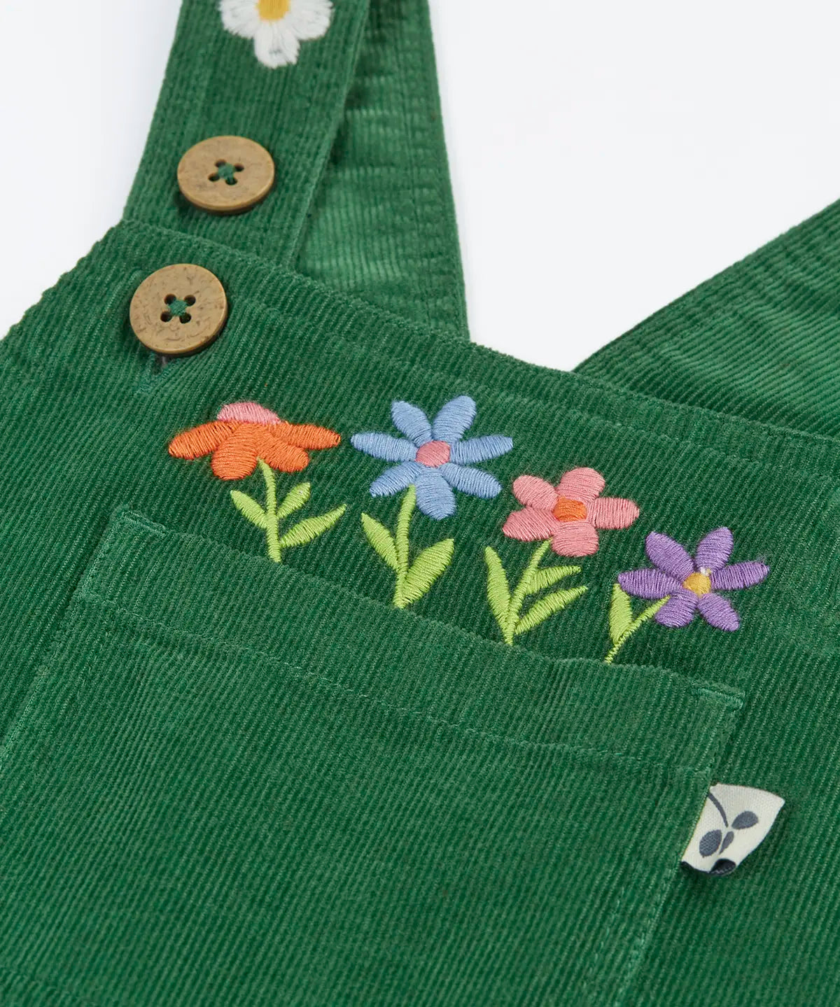 Close up of the embroidered flowers above the pocket on the front of the Frugi Miley holly green cord dungaree.