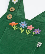 Close up of the embroidered flowers above the pocket on the front of the Frugi Miley holly green cord dungaree.