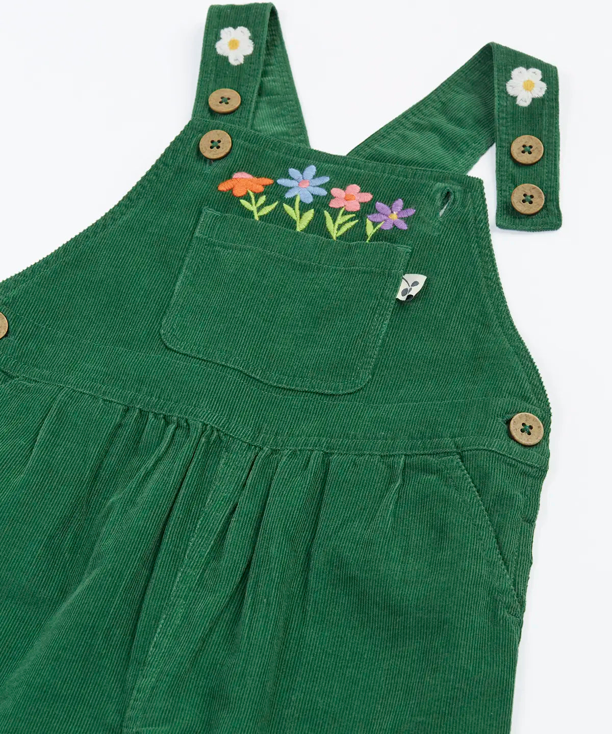 Close up of the front of the Frugi Miley holly green cord dungaree with flowers embroidery details, shown with one strap open.